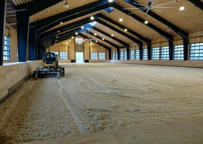 spreading ThorTurf on an indoor horse arena